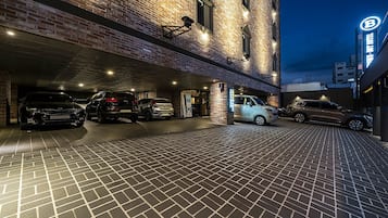 Guests can park their vehicles in the adjacent lot, adjacent to the building with a modern design.
