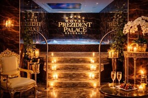 A luxurious hotel lobby with a grand staircase, elegant seating, and a view of a pool. - Prezident Palace Belgrade - Rooftop Pool & Spa Hotel (Belgrade)