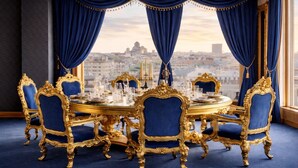 A luxurious dining room with ornate gold furniture, a round table, and blue curtains. - Prezident Palace Belgrade - Rooftop Pool & Spa Hotel (Belgrade)