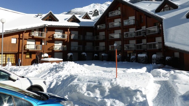 A wooden building with multiple balconies and a ski slope in the background. - Cozy 2-room apartment for 4 pers with pets and parking (Les Contamines-Montjoie)
