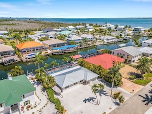 A coastal residential area with houses, a marina, and a clear view of the ocean.