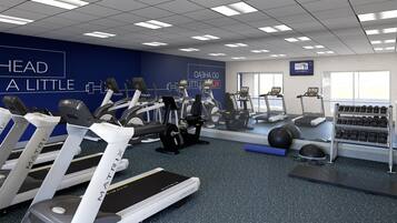 A gym with treadmills, elliptical machines, and a weight rack.