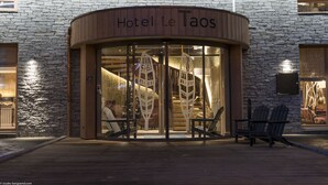 Hotel Le Taos met een gevel van steen en een houten inkom.