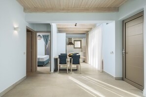 A hallway with a dining area, a kitchen, and a bedroom.