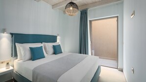 Une chambre à coucher comprenant un lit, une table de chevet, une lampe fixée au mur et une porte.