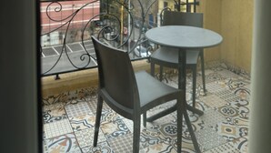A balcony with a patterned floor, a table, and two chairs. - Mar Mkhayel Studios (Beirut)