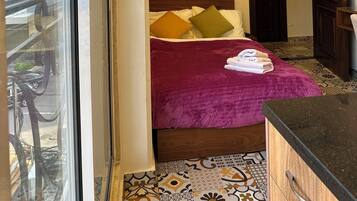 Habitación de hotel con cama, ventana, aire acondicionado instalado en la pared y piso con diseño.
