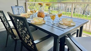 A dining table set on a balcony with chairs, a pitcher, glasses, and a bowl. - Spacious 2BR/2BA – Ground Level, Near Attractions (Branson)