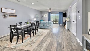 A spacious living room with a dining area, a balcony with curtains, and a view of the outdoors. - Spacious 2BR/2BA – Ground Level, Near Attractions (Branson)