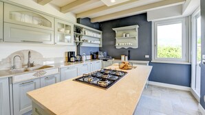 Una cocina moderna con una isla central, armarios empotrados y un ventanal con vistas.