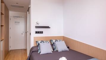 Edredones de plumas, escritorio, tabla de planchar con plancha