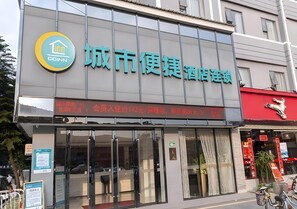 A hotel sign with a logo and name in Chinese characters.
