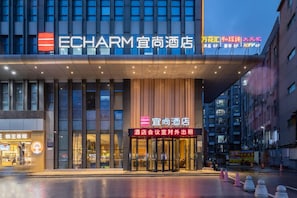 A hotel with a modern facade, large windows, and a prominent entrance. - Echarm Hotel Guangzhou Dayuan Time Plaza (Guangzhou)