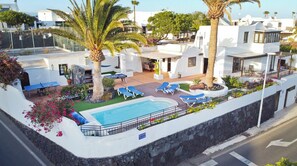 Relax by the pool surrounded by lush greenery and lounge chairs.