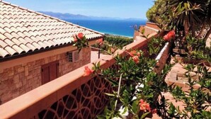 A building with a tiled roof overlooking a coastal view.
