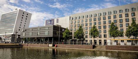 A modern building with a casino, a river in front, and a clear sky.