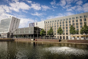 Un edificio moderno con un casino, un río al frente y un cielo despejado.