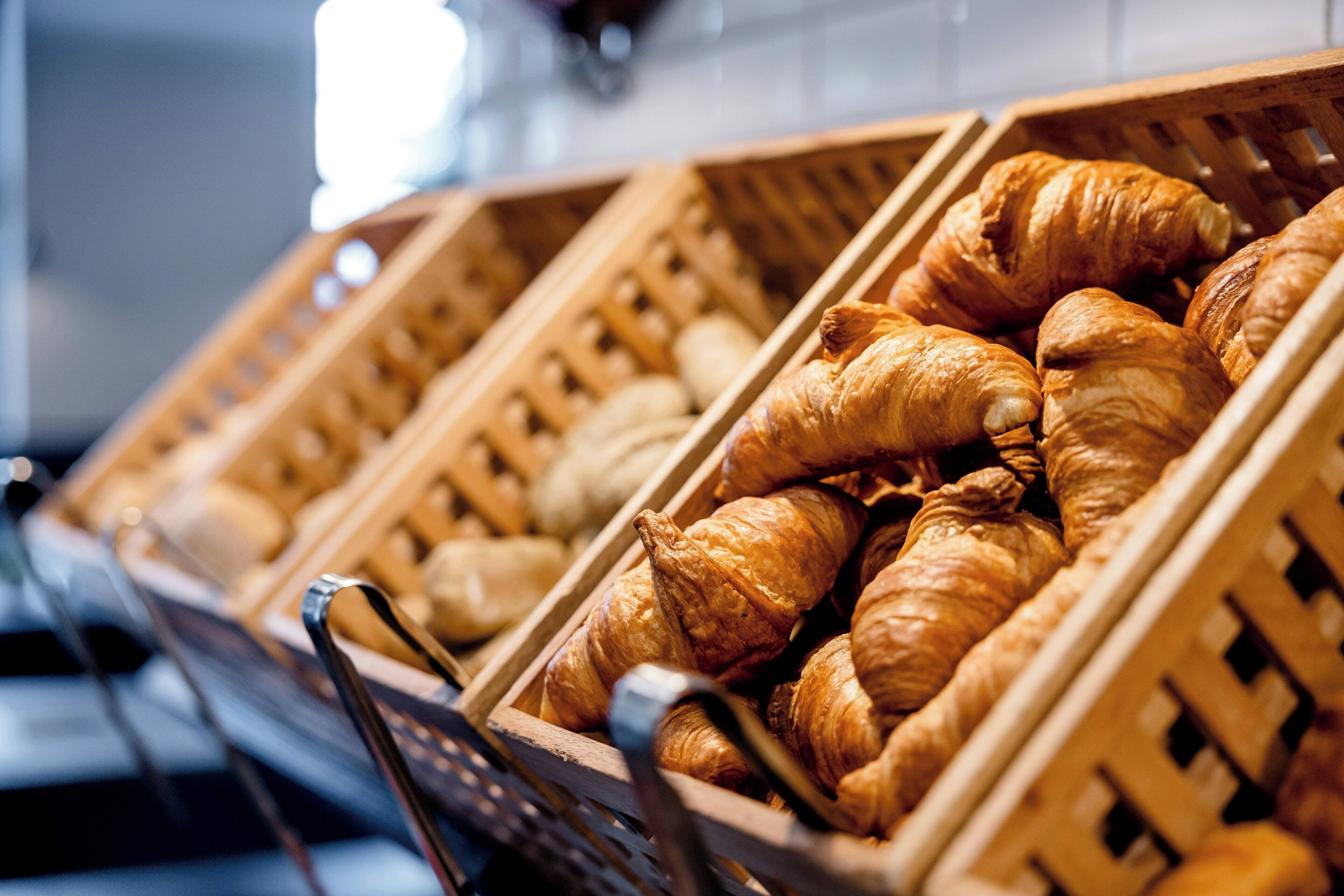 A display of croissants in wooden baskets.