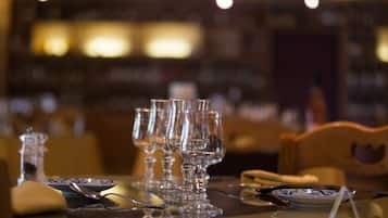 A dining table set with clear glassware, plates, and cutlery.