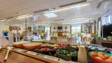 A buffet area with various food options including cold cuts, cheeses, and eggs.