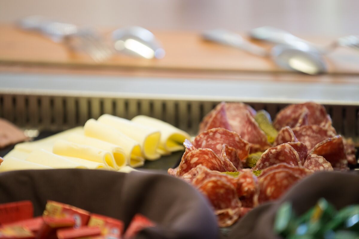 Une planche de charcuterie avec différentes sortes de viandes et de fromages.