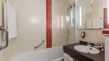 Ein modernes Badezimmer mit Badewanne, Dusche, Waschbecken und einem großen Spiegel.