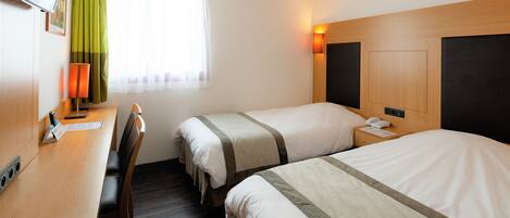 Een hotelkamer met twee bedden, een bureau en een stoel.