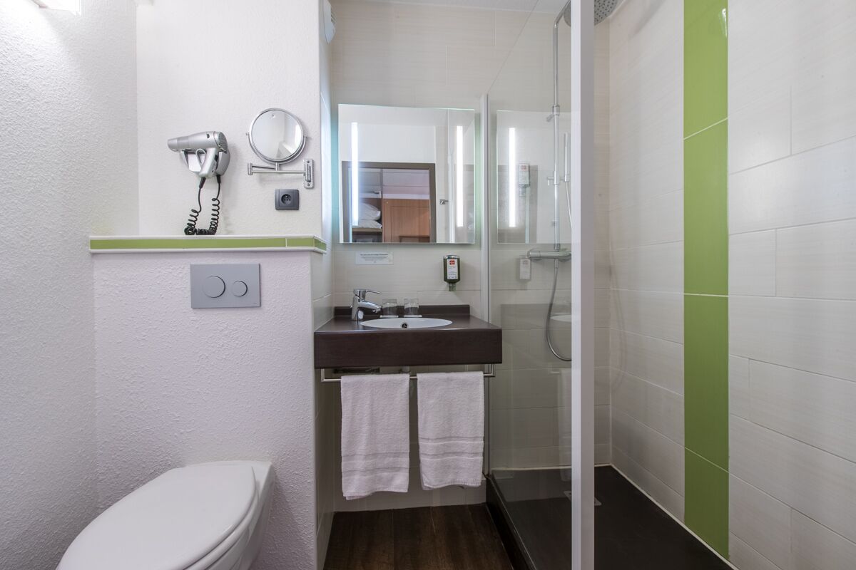 Un baño con inodoro, lavabo y ducha.