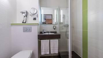 Un baño con inodoro, lavabo y ducha.