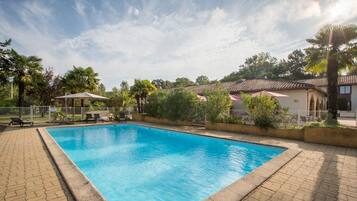 Alberca al aire libre por temporada y sombrillas en la alberca