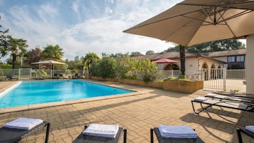 Een seizoensgebonden buitenzwembad en parasols bij het zwembad