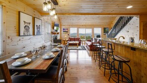 Un intérieur en bois comprenant un espace repas, un bar et des sièges.