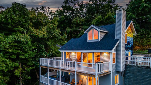 Une maison à deux étages avec un balcon et une cheminée.