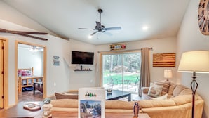 A living room with a sofa, a coffee table, a TV, and a fireplace. - Pet-Friendly Woodruff Cabin Near Lakes (Woodruff)