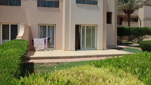 A multi-story building with balconies, large windows, and a well-maintained garden. - One-Bedroom Apartment with a Garden in Sahl Hasheesh (Hurghada)