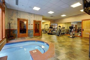A gym with a swimming pool, exercise equipment, and a mirrored wall. - 3066 Timbers 2 Bedroom Condo by RedAwning (Keystone)