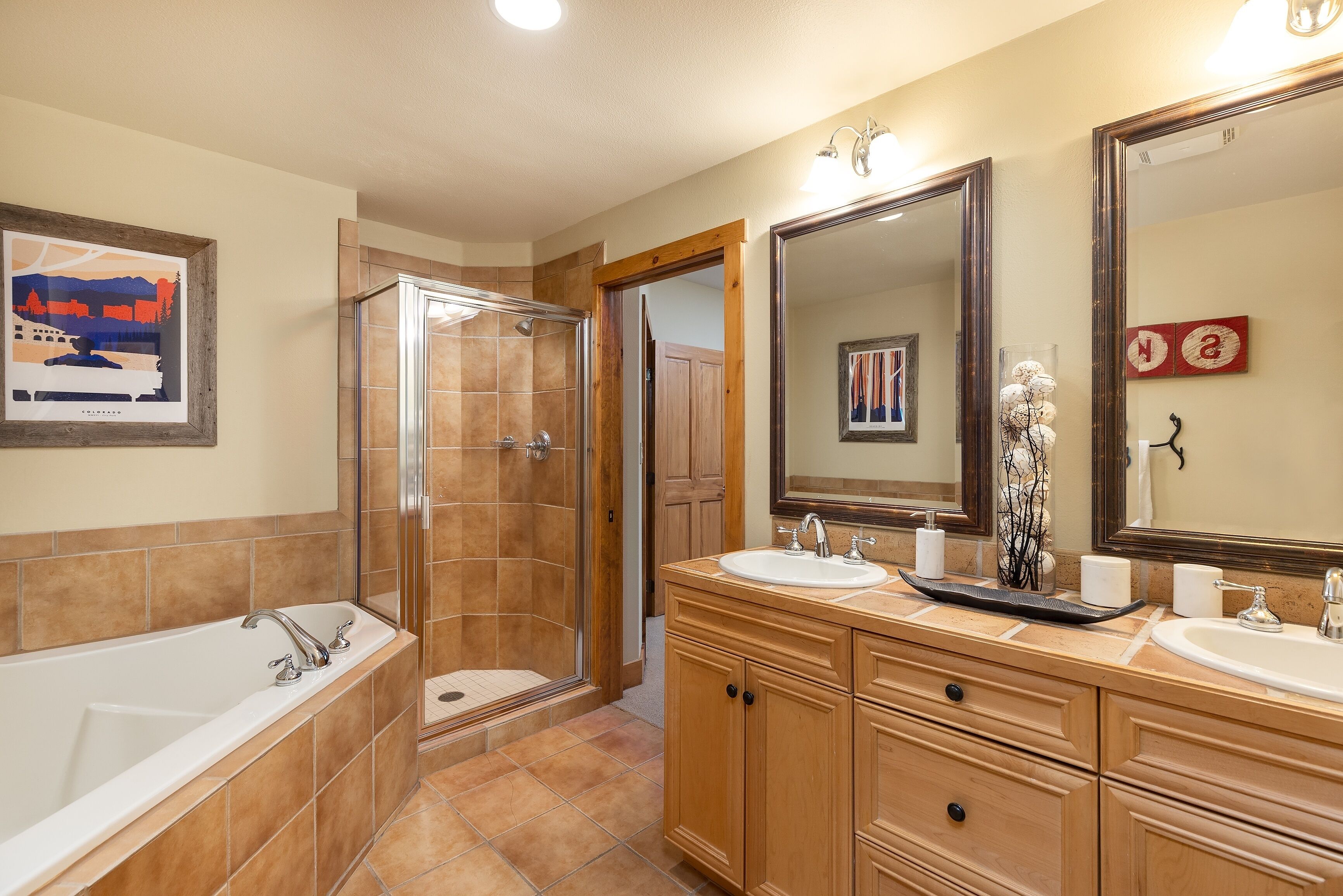 A bathroom with a bathtub, a shower, and a vanity with a sink and mirror.