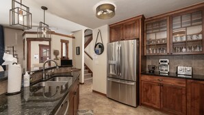 A modern kitchen with stainless steel appliances, wooden cabinets, and a granite countertop. - Cozens Pointe B-301 3 Bedroom Condo by RedAwning (Fraser)