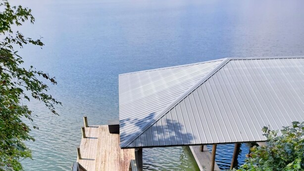 Una escalera de madera que conduce a un muelle sobre el agua, rodeado de vegetación.