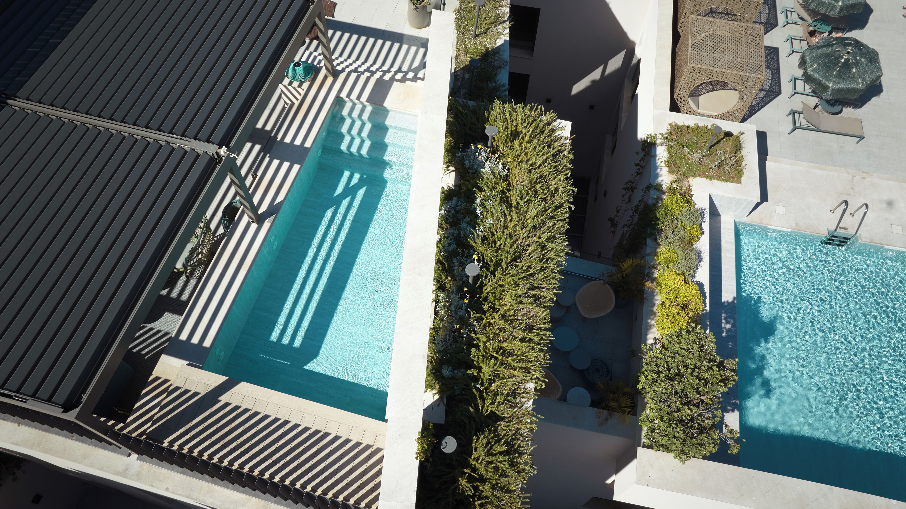 Eine Vogelperspektive eines Hotels mit Schwimmbad, Lounge-Bereich und Außenbereich.