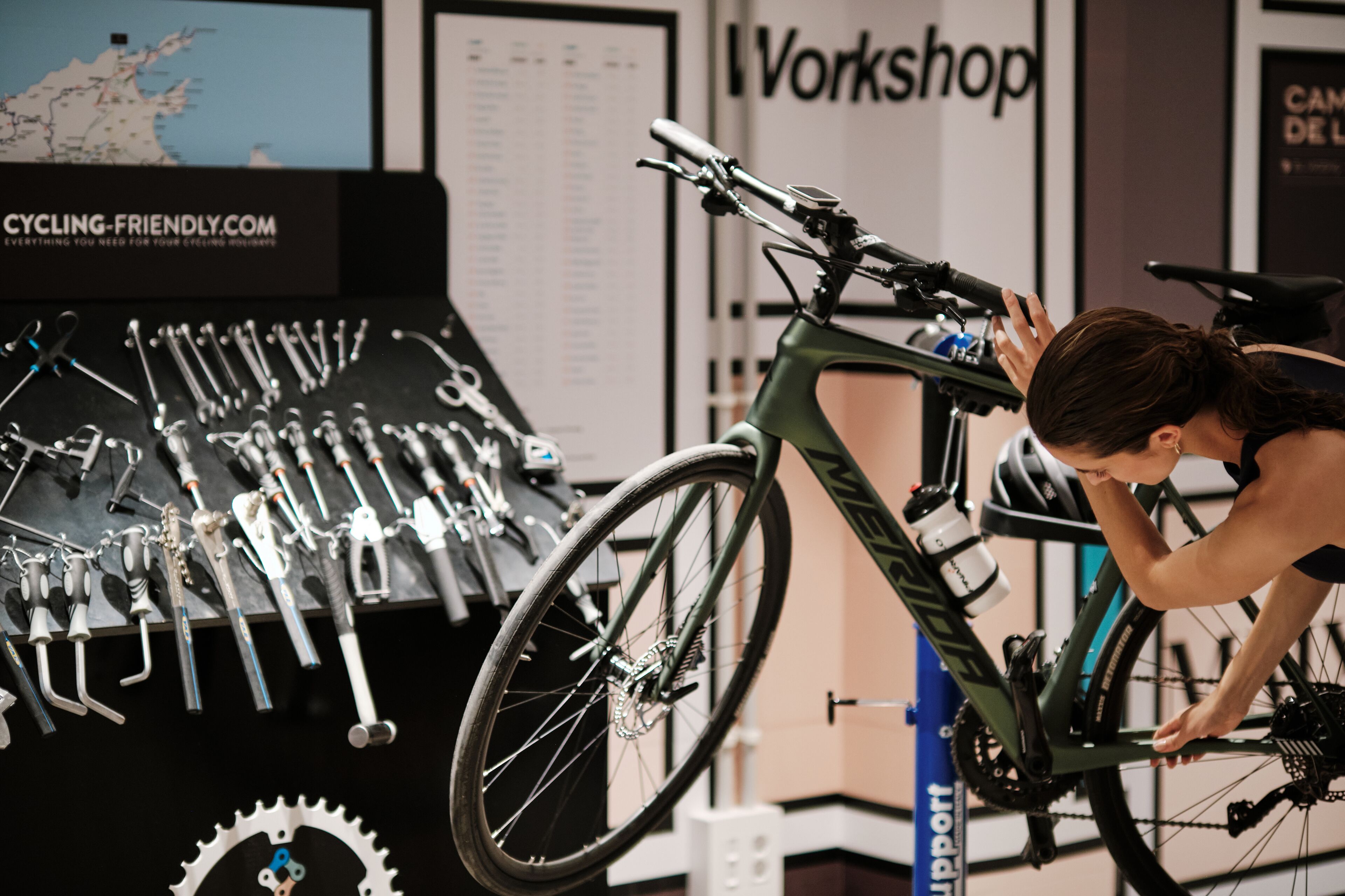 A bicycle repair station with tools and a map in the background.