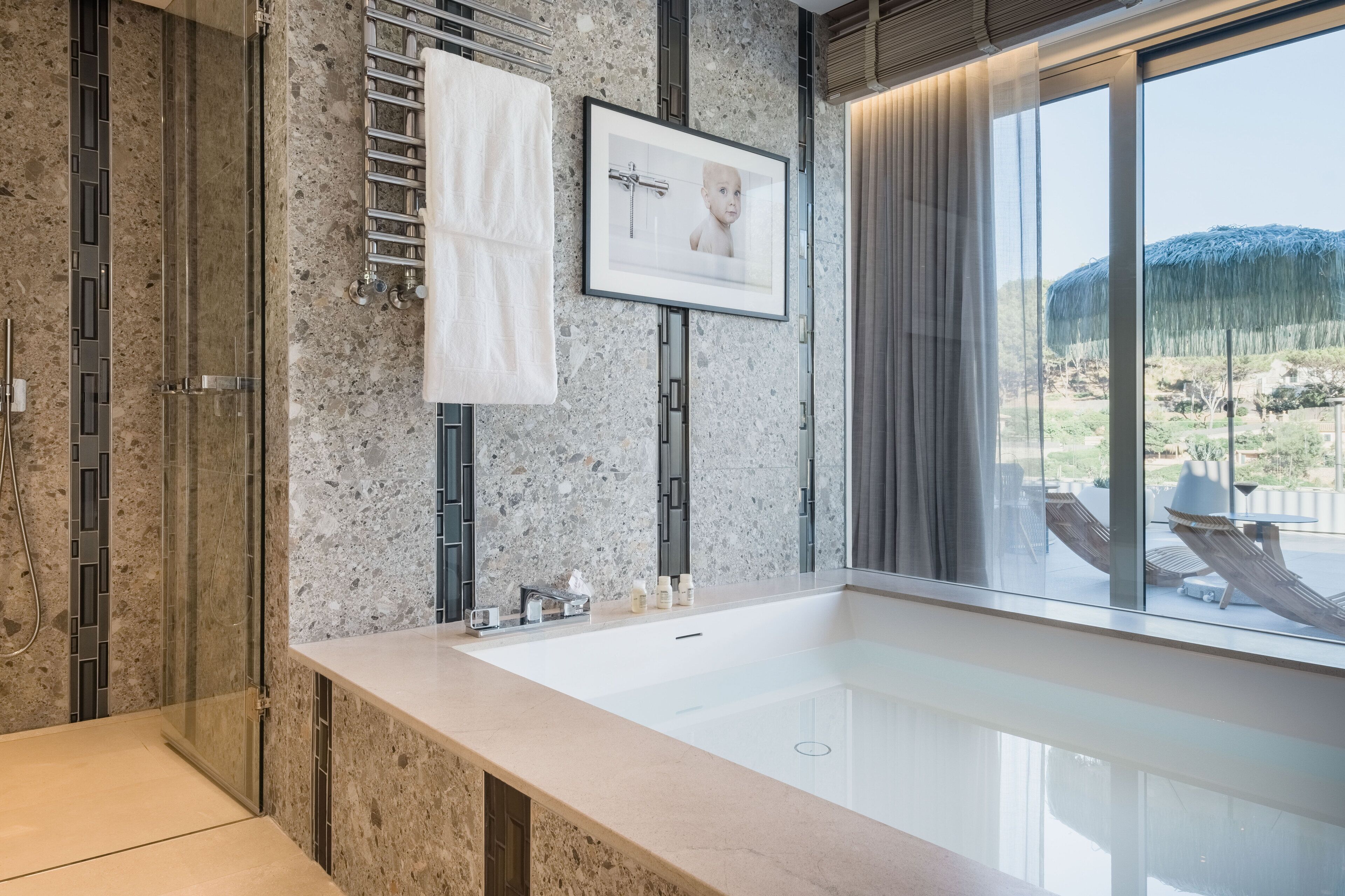 Un baño moderno con una bañera grande, una cabina de ducha de vidrio y vistas al exterior.