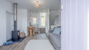 Un salon chaleureux avec une cheminée, un canapé, une table basse et un tapis.
