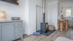 Une cuisine moderne dotée d’une cuisinière intégrée, de meubles gris et d’un plancher en bois.