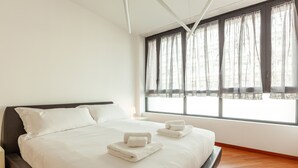 A modern hotel room with a large bed, white linens, and a view through sheer curtains. - easyhomes - Madonnina view (Milan)
