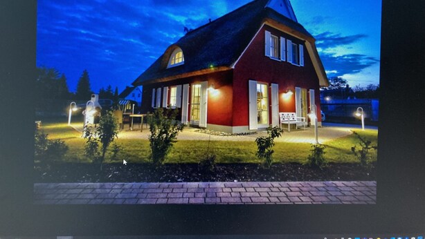 Una casa con fachada roja, techo empinado y chimenea.
