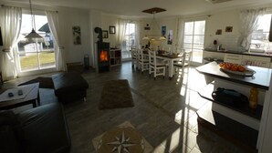 Amplia sala de estar con chimenea, comedor y cocina.