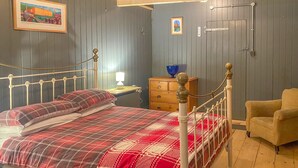 Ein Schlafzimmer mit einem Bett, einem Sessel, einem Schminktisch und einem Nachttisch.