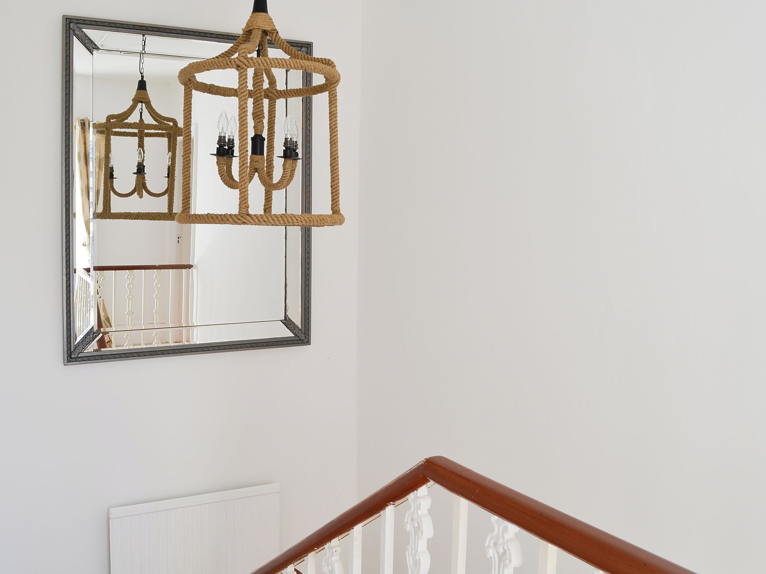 Un lustre à motifs de cordes suspendu au-dessus d’un miroir.