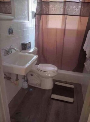 A small bathroom with a toilet, sink, and shower curtain. - Private Suite # 11, five minutes walk to beach (Pompano Beach)